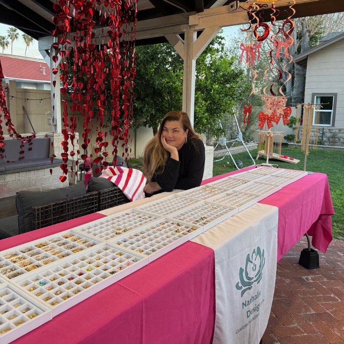 Woman sitting at a table with jewelry display outdoors