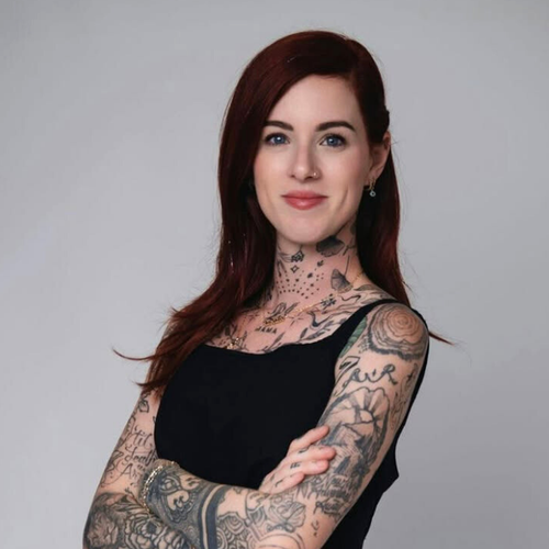 Woman with dark red hair with tattoos on a plain background